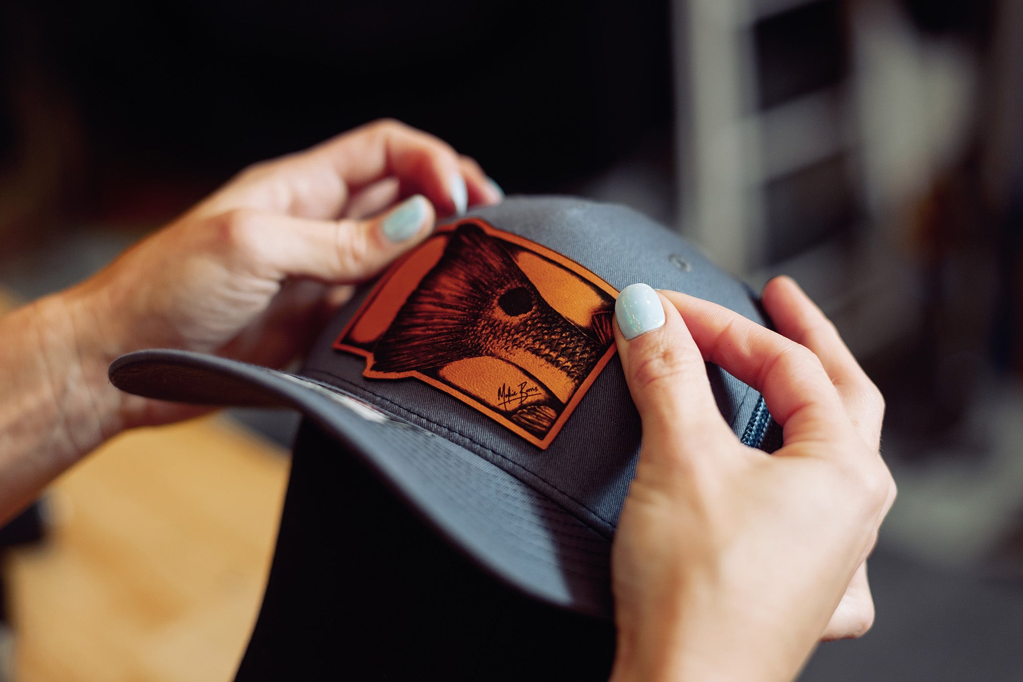 a Richardson 112 trucker hat in dark navy with a leather patch of a snook, ideal for recreational saltwater fishermen or as a thoughtful gift for enthusiasts looking for stylish and themed headwear for fishing activities