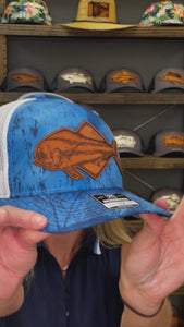 Video showcasing a Richardson 112 snap-back trucker hat in Realtree Blue Camo with a leather patch depicting a dolphin (also known as mahi-mahi or dorado), perfect for recreational saltwater fishermen and those interested in offshore fishing accessories and hats.